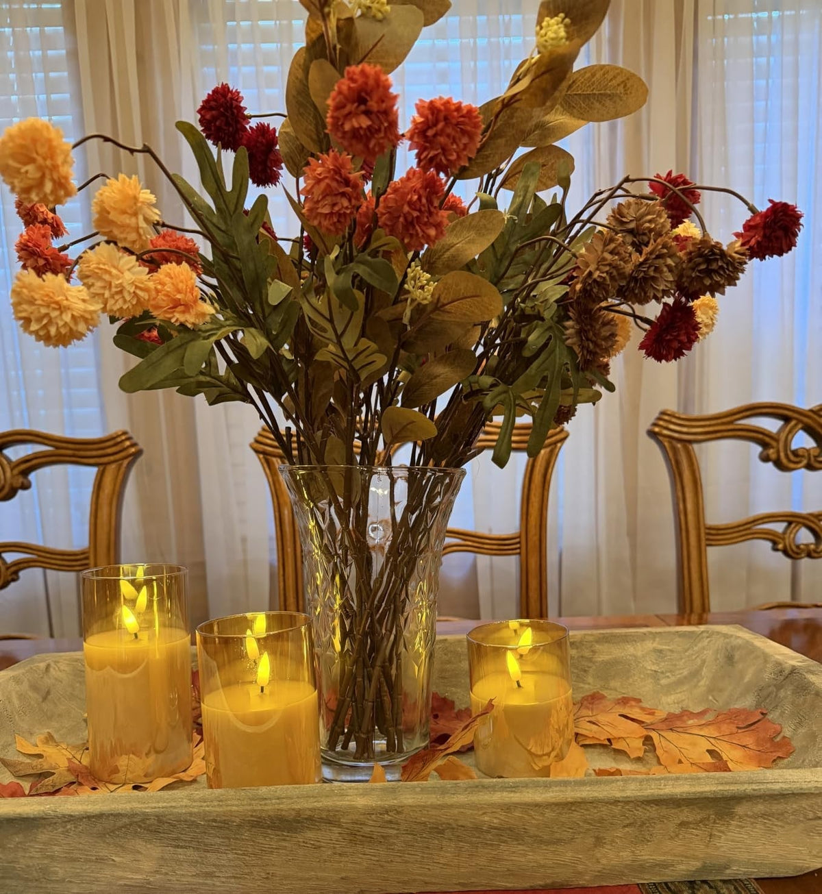 Flameless candles as a dining table centrepiece with flowers