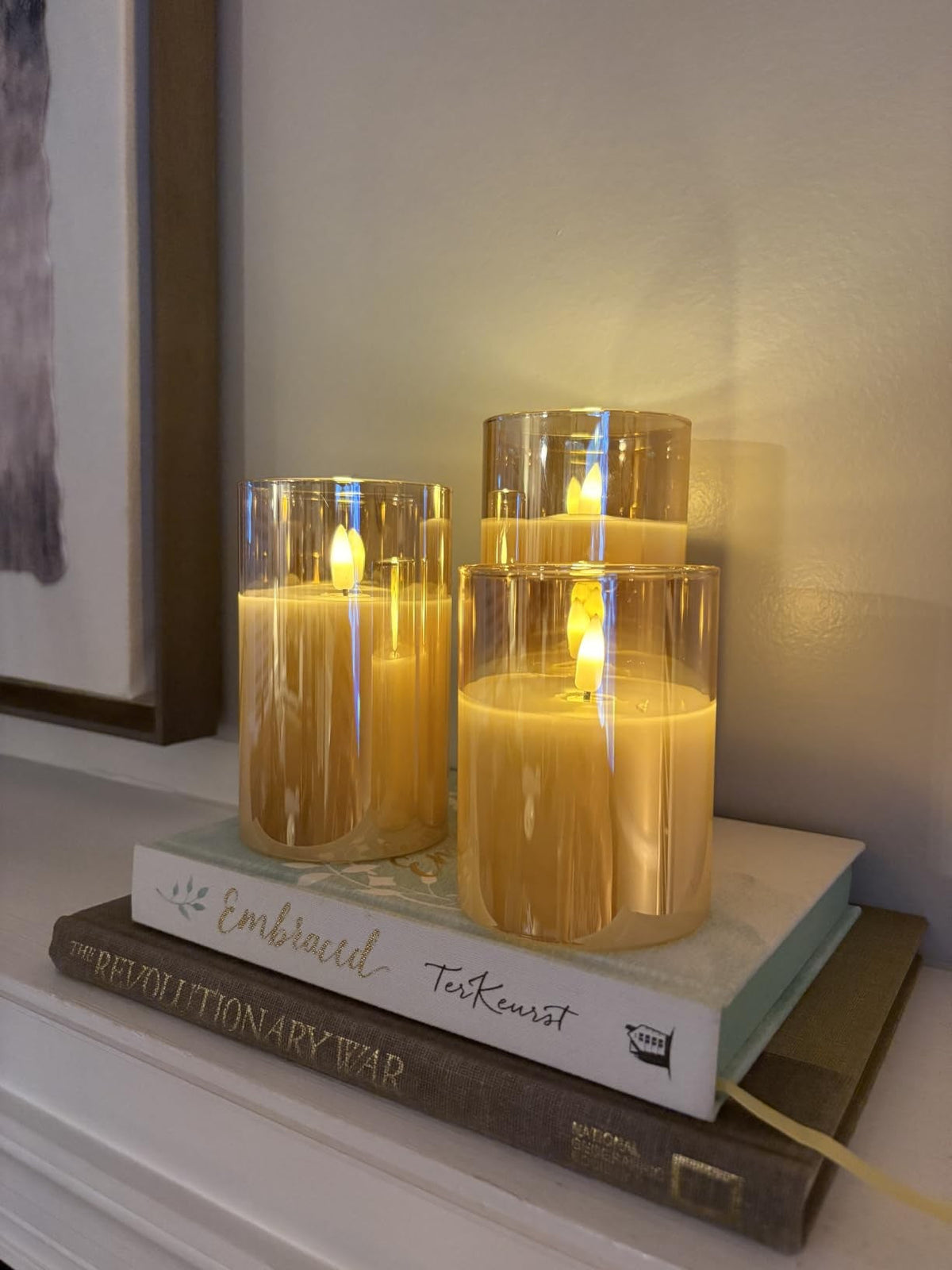 Flameless glass candles styled on books on a shelf