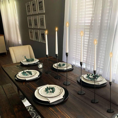 Black taper candle holders on a dining table