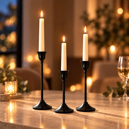 Black taper holders in warm candlelight